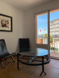 a glass table and chairs in a room with a window at Hotel Arena in Ribadesella