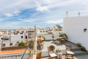 uma varanda com cadeiras e uma mesa num edifício em 3 Marias Guest House B&B em Lagos