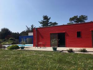 - un bâtiment rouge avec une piscine en face dans l'établissement Les Naiades, à Dolus-d'Oléron