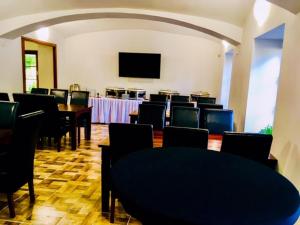 sala konferencyjna ze stołami i krzesłami oraz telewizorem z płaskim ekranem w obiekcie Penzion Sloup w mieście Sloup
