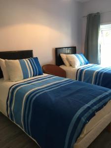 a bedroom with two beds with blue and white sheets at Lily's in Manorhamilton