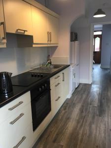 a kitchen with white cabinets and a black stove top oven at Lily's in Manorhamilton