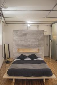 a large bed in a room with a concrete wall at CasaMia in Rome