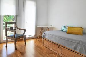 sypialnia z łóżkiem, krzesłem i oknem w obiekcie PANORAMIC HOME w mieście Benalmádena
