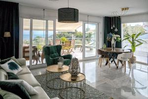 a living room with a couch and a table and chairs at PANORAMIC HOME in Benalmádena