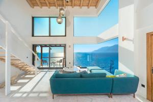 a living room with a blue couch and a large window at Mandalina Suites in Kaş