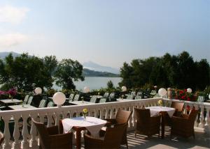 uma varanda de um restaurante com mesas e cadeiras em Hotel Garni Dorferwirt em Tiefgraben