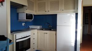 a kitchen with white cabinets and a white refrigerator at CA NA ROSA Son Bou in Alaior
