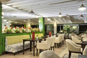 a restaurant with tables and chairs and flowers at Ephesia Holiday Beach Club in Kuşadası