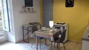 a dining room with a table and chairs and a stove at Le Petit Dyke in Le Puy en Velay