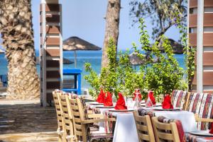 a row of tables and chairs with red napkins at Ephesia Holiday Beach Club in Kuşadası