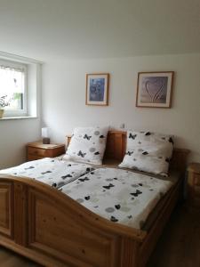 a bedroom with a large wooden bed with two pillows at idylische Ferienwohnung in Schollbrunn