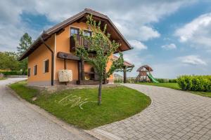 uma pequena casa com uma árvore e um parque infantil em Wineyard getaway house em Sevnica