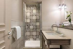 a bathroom with a sink and a shower at Royal Madeleine Hotel & Spa in Paris