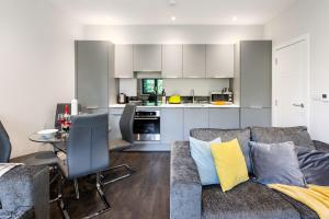 a living room with a couch and a kitchen at homely - Watford Premier Apartments (Warner Bros Studio) in Watford