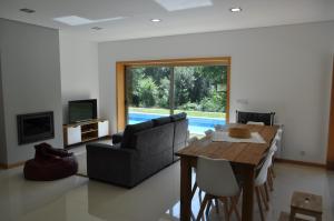ein Wohnzimmer mit Sofa und Tisch in der Unterkunft Casa da Quinta do Sóto in Terras de Bouro