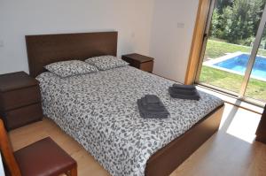 ein Schlafzimmer mit einem Bett und einem großen Fenster in der Unterkunft Casa da Quinta do Sóto in Terras de Bouro + 24 Fotos