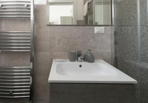 uma casa de banho com um lavatório branco e um espelho. em B&B Vittoria em Gallipoli