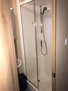 een douche met een glazen deur in de badkamer bij Luxury Holiday Caravan Home in Newquay
