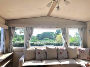 a living room with a couch and a large window at Luxury Holiday Caravan Home in Newquay