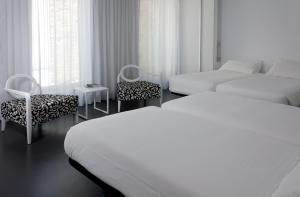 Łóżko lub łóżka w pokoju w obiekcie Moure Hotel