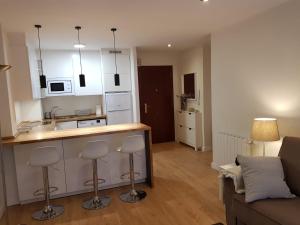 a kitchen and living room with a counter and stools at Tazones CASA AURO VUT1198AS centrico y con vistas al mar in Tazones
