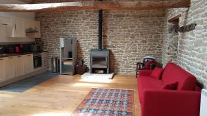 sala de estar con sofá rojo y pared de ladrillo en le jardin des chênes, en Plumelec