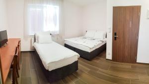 Apartment De Luna في براغ: غرفة صغيرة بها سريرين وخزانة