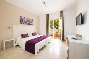 a hotel room with a bed and a balcony at Hotel Flor Los Almendros in Paguera