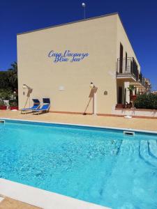 a building with a swimming pool in front of a house at Casa Vacanza Blue Sea in San Vito lo Capo