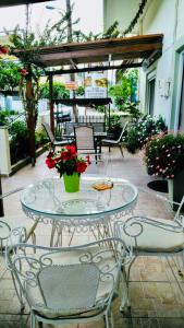een glazen tafel met een vaas met bloemen op een patio bij Filoxenia in Choudetsi