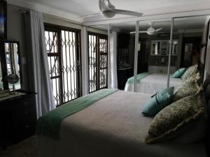 a bedroom with a bed and a large mirror at 94 Sea Cottage in Mossel Bay