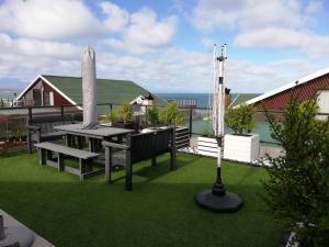 a patio with a table and benches on the grass at 94 Sea Cottage in Mossel Bay
