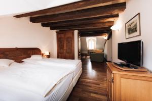 Schlafzimmer mit einem Bett und einem Flachbild-TV in der Unterkunft Hotel Weisser Bock in Heidelberg