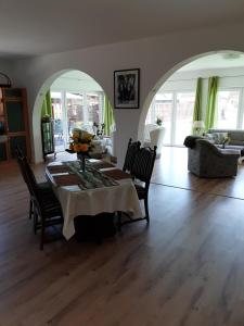 salon ze stołem, krzesłami i kanapą w obiekcie Ferienwohnung Uhlenbusch Paradise w mieście Friesoythe