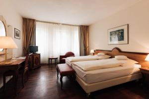 a hotel room with two beds and a desk at Hotel Weisser Bock in Heidelberg