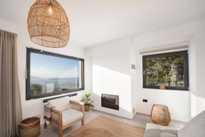 a living room with a large window and a chair at Forest View Villas 1 in Lagoúdi Zía