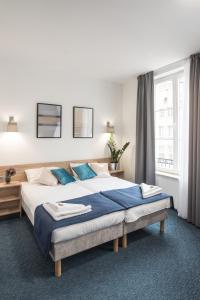 a bedroom with a large bed with blue pillows at Fama Residence Gdańsk Old Town in Gdańsk