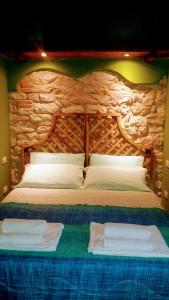 ペルゴラにあるAgriturismo Cà Sorciの石壁のベッドルーム1室(大型ベッド1台付)