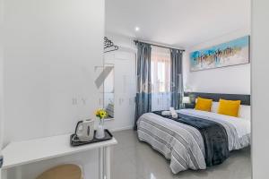 a white bedroom with a bed and a desk at AYZ Sierra de Meira - Auto check-in property in Madrid