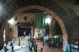 ein Esszimmer mit Tischen und Stühlen sowie einem Kamin in der Unterkunft Agriturismo L'Antico Casale in Altomonte
