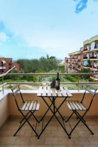 una mesa con 2 sillas y una botella de vino en el balcón en Ginevra Apartment, en Cefalú