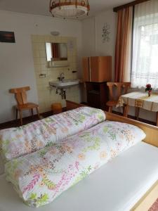 a bedroom with a bed and a kitchen with a sink at Haus Marion in Jerzens