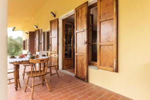 un porche con mesa y sillas en una casa en Casa Ermo Colle, en Sant'Ermo