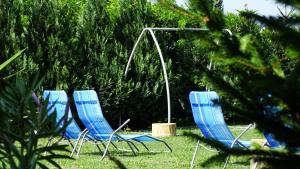 drie blauwe ligstoelen in het gras bij Rider Beach in Balatonszemes