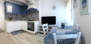 a kitchen with a table and a kitchen with blue cabinets at Casa Elisa - Venezia in Chioggia