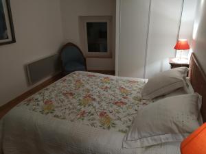 1 dormitorio con 1 cama con colcha de flores en Le Térébinthe B&B, en Lauris