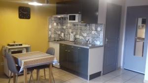 a kitchen with a table and a sink and a counter at Le Petit Dyke in Le Puy en Velay