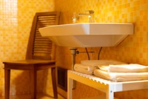 bagno con lavandino e un mucchio di asciugamani di B&B Muro Torto Lucera a Lucera