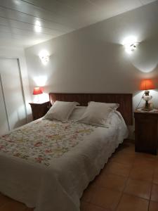 1 dormitorio con 1 cama con sábanas blancas y lámparas rojas en Le Térébinthe B&B, en Lauris